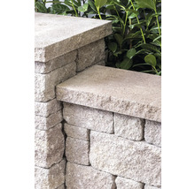 Detailaufnahme einer Mauer aus Mauersteinen mit Abdeckplatten
