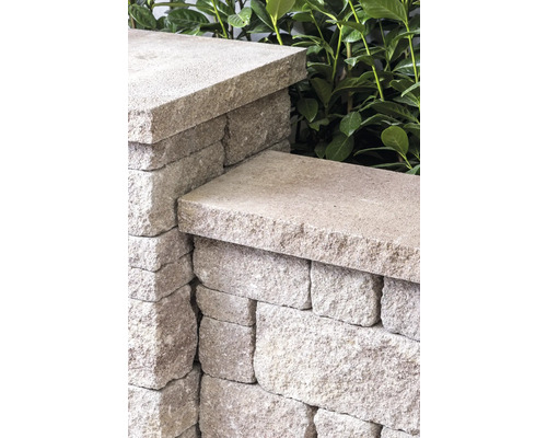 Detailaufnahme einer Mauer aus Mauersteinen mit Abdeckplatten