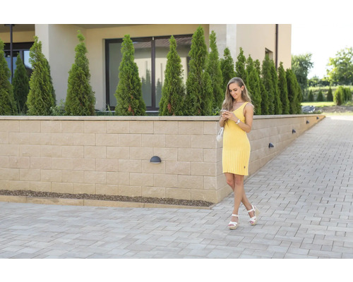 Gestaltungsidee für einen Außenbereich mit Pflastersteinen und einer Mauer mit Beleuchtung