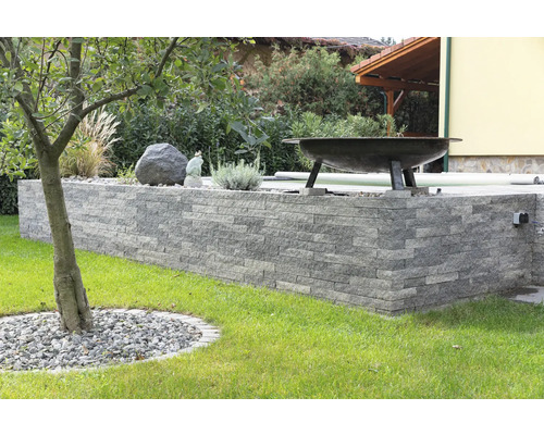 Garten mit Mauer aus Natursteinen, Baum und Grill