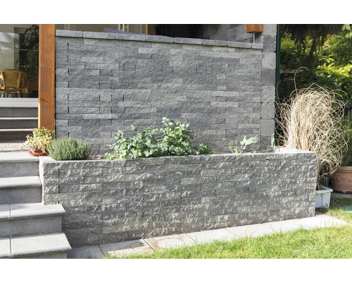 Gestaltungsidee mit einer grauen Mauer aus Mauersteinen im Garten
