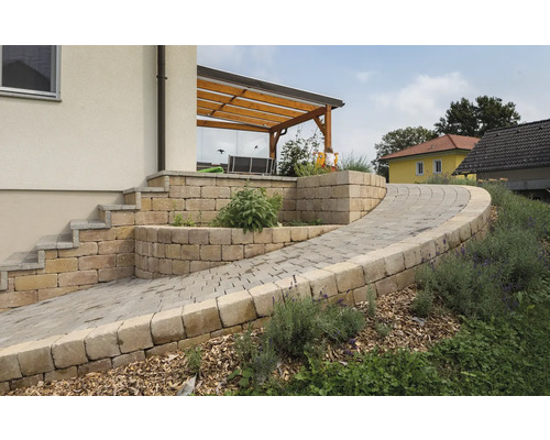 Gartenanlage mit Pflastersteinen, Stufen und einer überdachten Terrasse