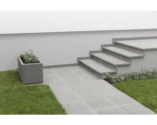 Außenbereich mit Steintreppe, Pflastersteinen und bepflanztem Blumenkasten