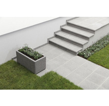 Außenbereich mit Treppe, Pflastersteinen und rechteckigem Pflanzgefäß mit Bepflanzung