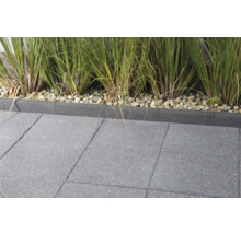 Terrasse mit grauen Betonpflastersteinen und Rasenkante