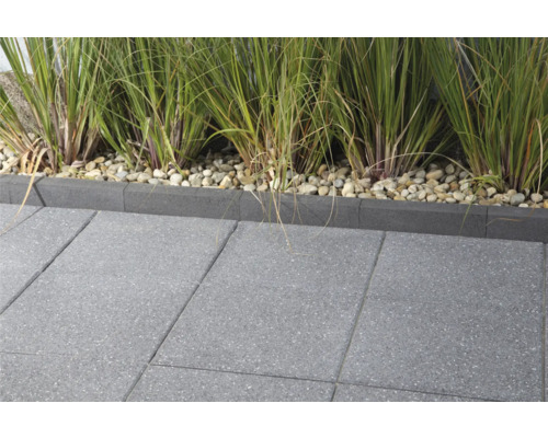 Terrasse mit grauen Betonpflastersteinen und Rasenkante