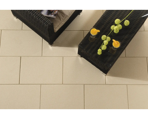 Terrasse mit Betonplatten, Rattanmöbeln und Getränken für eine entspannte Atmosphäre im Freien
