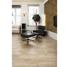 Heller Wohnraum mit Holzboden, Sessel und Stehlampe
