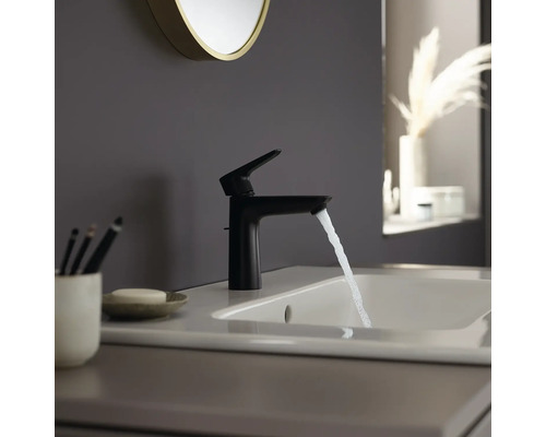 Schwarzer Waschtischmischer auf Waschbecken mit laufendem Wasser.