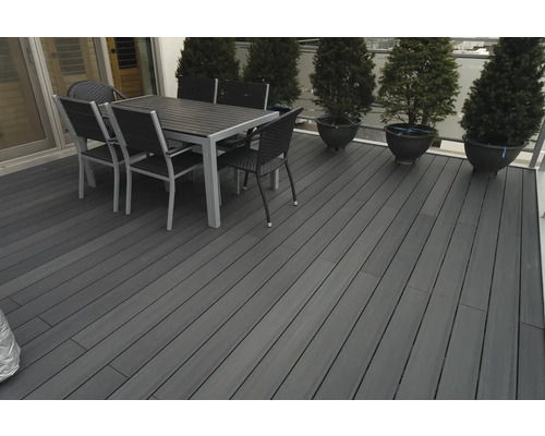 Terrasse mit Terrassendielen, Esstisch und Stühlen im Außenbereich.