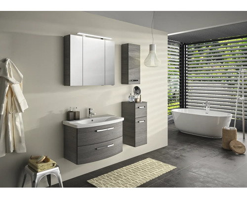 Badezimmer mit Waschtisch, Spiegelschrank, Hochschrank und Badewanne.