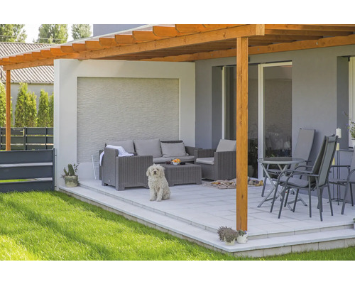 Terrasse mit Holzpergola, Gartenmöbeln und Hund