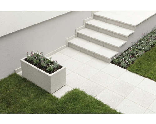 Außenbereich mit Steintreppe, Pflastersteinen, Blumenbeet und rechteckigem Pflanzgefäß mit Bepflanzung