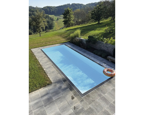 Schwimmbad im Freien mit Pflastersteinen und grüner Landschaft
