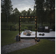 Garten mit Holzterrasse, Sitzgelegenheiten und Lichterkette für eine gemütliche Atmosphäre