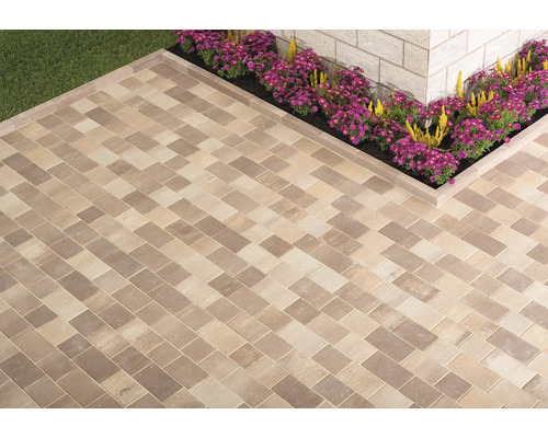 Terrasse mit rechteckigen Pflastersteinen in Fischgrätmuster und Blumenbeet