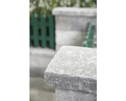 Detailaufnahme eines grauen Mauersteins im Garten