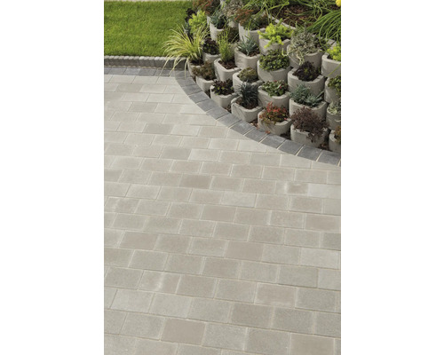 Garten mit Pflastersteinen und bepflanzten Betonsteinen