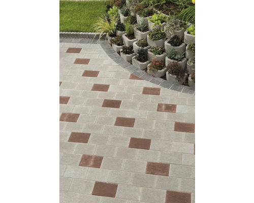 Gartenweg mit Pflastersteinen und bepflanzter Hangbefestigung