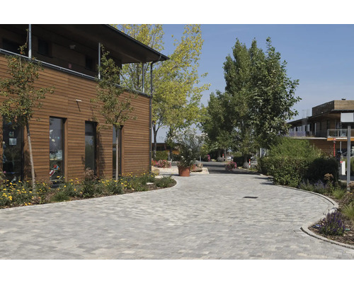 Außenansicht eines Gebäudes mit Holzfassade und Pflastersteinen