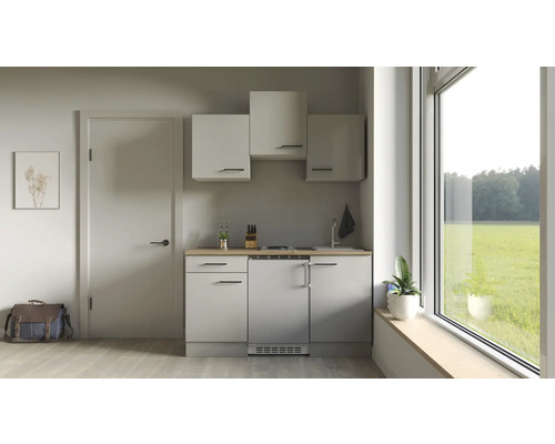 Kleine Küche mit Hängeschränken, Spüle, Kochfeld und Kühlschrank in hellem Raum