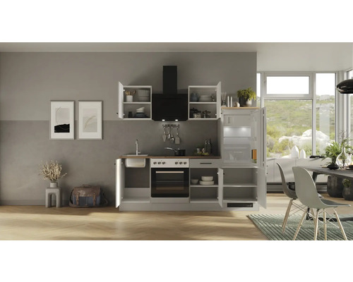 Komplette Einbauküche mit Elektrogeräten, Dunstabzugshaube und Kühlschrank in einem hellen Raum