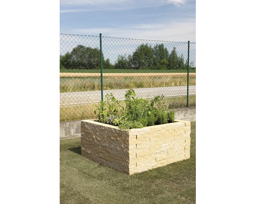 Hochbeet aus Stein mit Pflanzen im Garten