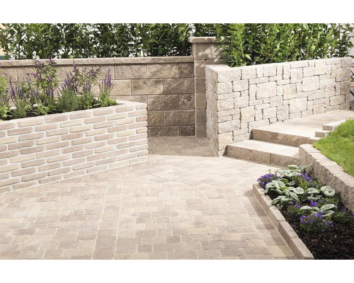 Terrasse mit Pflastersteinen, Mauer und Bepflanzung