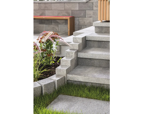 Außentreppe aus Betonsteinen in einem Garten.