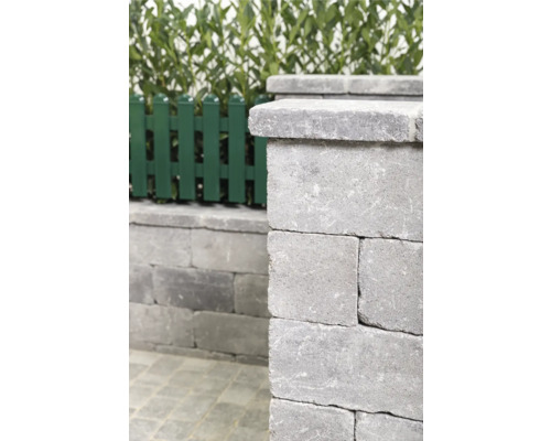 Graue Gartenmauer aus Betonsteinen mit Gartenzaun