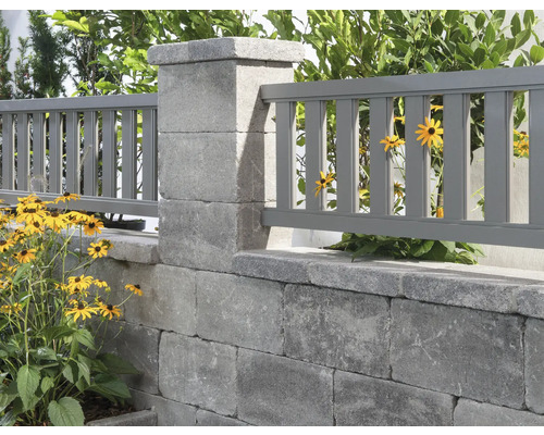 Gartenmauer mit Zaunelementen und Pflanzen