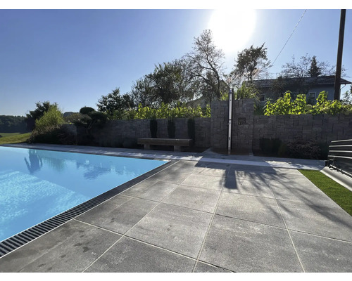 Außenbereich mit Pool, Steinmauer und Sitzbank