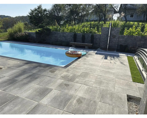 Außenbereich mit Schwimmbad und grauen Terrassenplatten