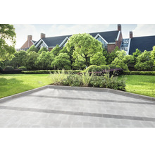 Gepflasterter Gartenweg vor einem Haus mit Gartenanlage