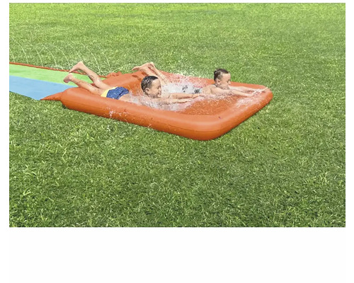 Zwei Kinder spielen auf einer aufblasbaren Wasserrutsche im Garten.