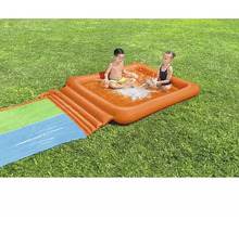 Aufblasbare Wasserrutsche mit Planschbecken für Kinder auf einer Wiese mit zwei Kindern