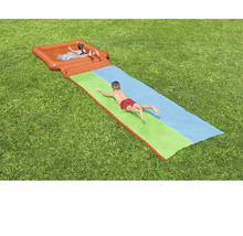 Wasserrutsche für Kinder auf einer Rasenfläche mit spielenden Kindern