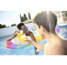Zwei Männer stoßen mit Getränken in einem Pool mit einer aufblasbaren Schwimmhilfe an.