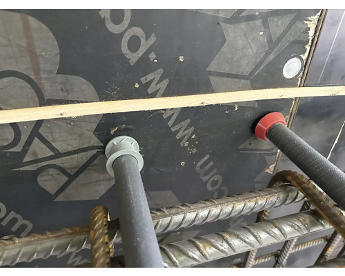 Detailansicht einer Baustelleneinrichtung mit Abstandhaltern, Bewehrung und Schalung