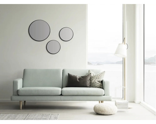 Wohnzimmer mit Sofa, Stehlampe und runden Spiegeln