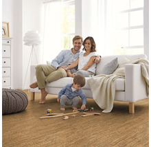 Familie entspannt sich auf einem Sofa in einem Wohnzimmer mit Korkboden.