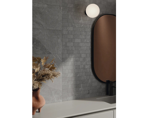 Badezimmer mit grauen Fliesen, Spiegel und Lampe