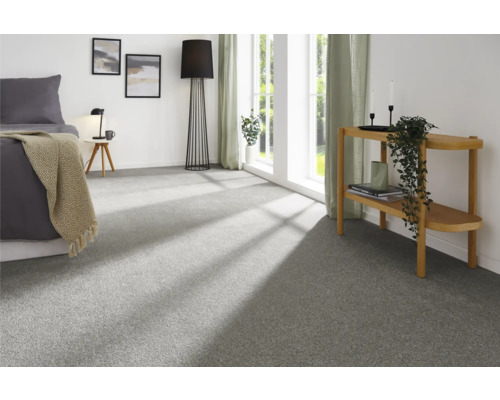 Helles Schlafzimmer mit Teppichboden, Bett, Stehlampe und Beistelltisch