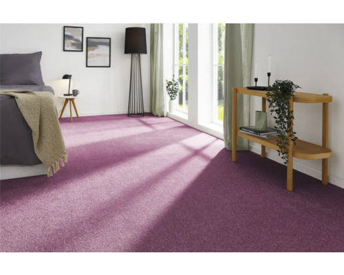 Schlafzimmer mit lila Teppichboden, Bett, Fenster und Dekoration für eine gemütliche Atmosphäre.