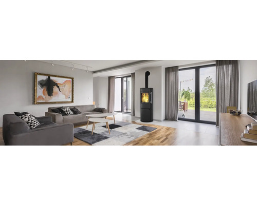 Wohnzimmer mit Sofa, Sessel, Kaminofen und Kunstdruck