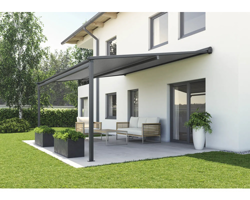 Terrasse mit Markise, Gartenmöbeln und Bepflanzung vor einem Haus