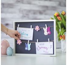 Dekoration mit Oster- und Frühlingsmotiven an einer Tafel mit Wäscheklammern.