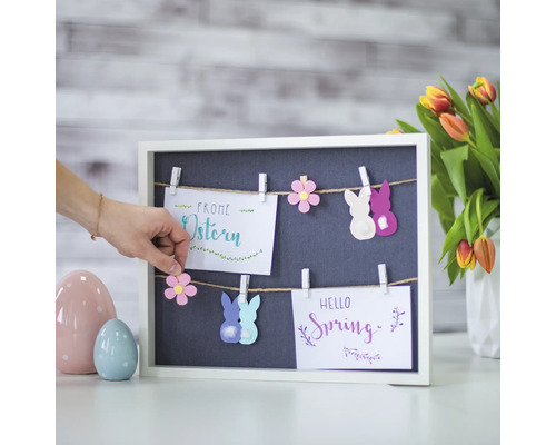 Dekoration mit Oster- und Frühlingsmotiven an einer Tafel mit Wäscheklammern.