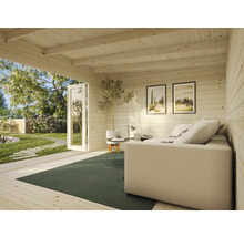 Innenansicht eines Gartenhauses mit Couch, Teppich und Dekoration