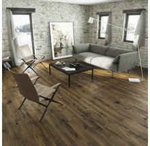 Wohnzimmer mit Holzboden, Sofa und Sesseln vor einer Steinwand